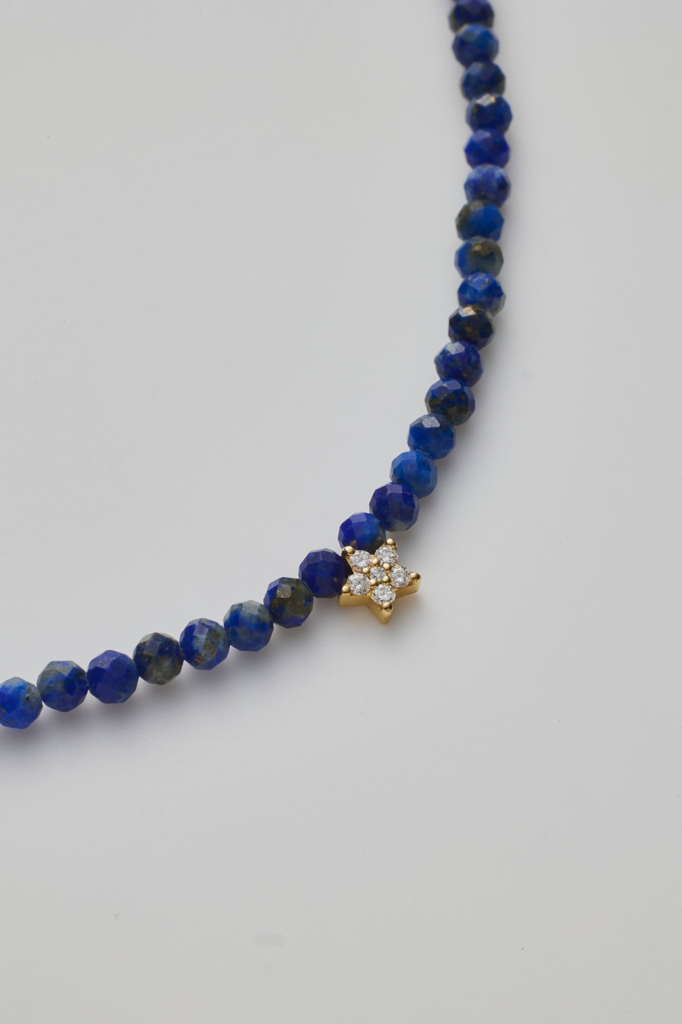 Delicate bracelet with Lapis lazuli beads and a diamond star charm, elegantly crafted.