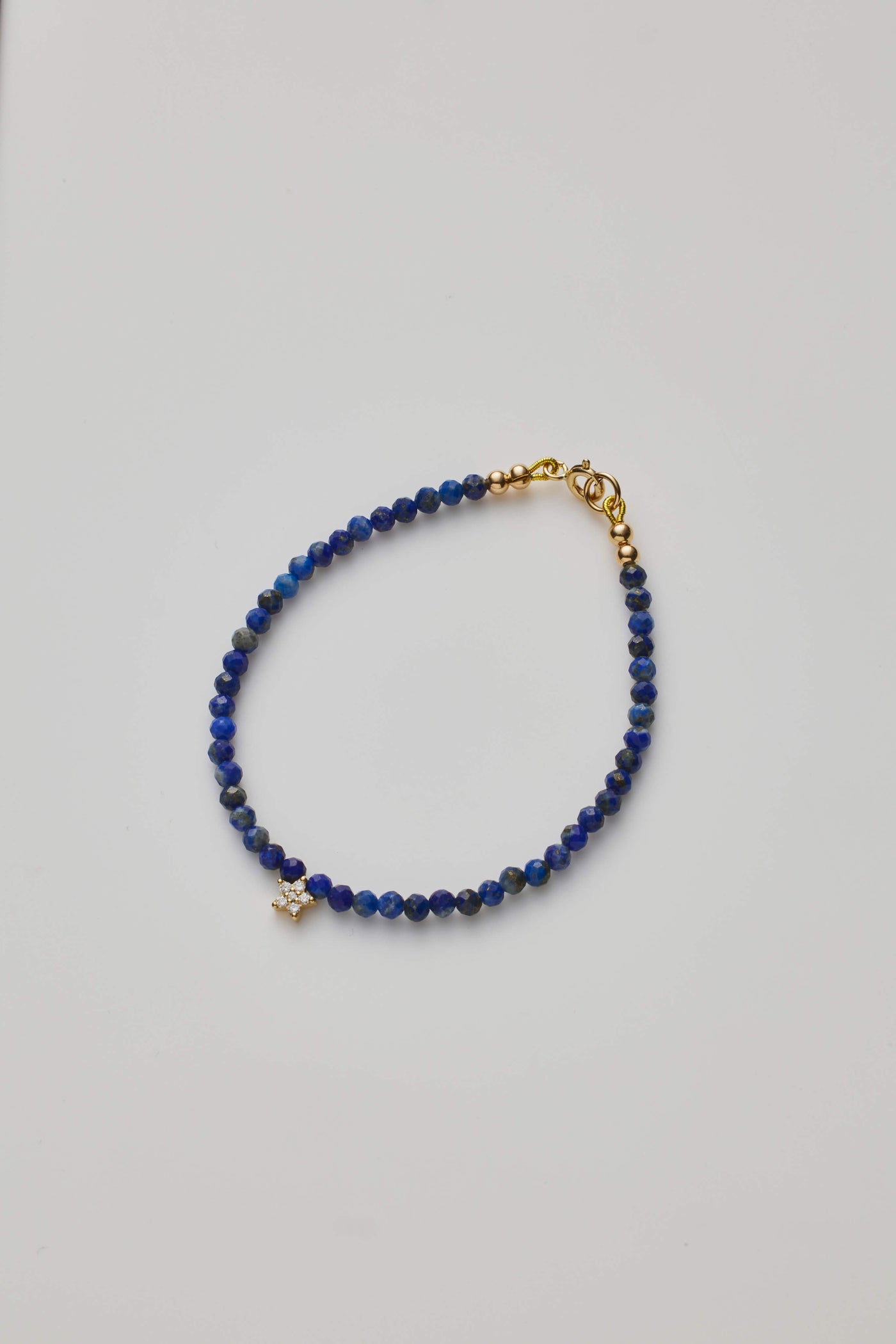 Delicate bracelet with Lapis lazuli beads and a diamond star charm, elegantly crafted.