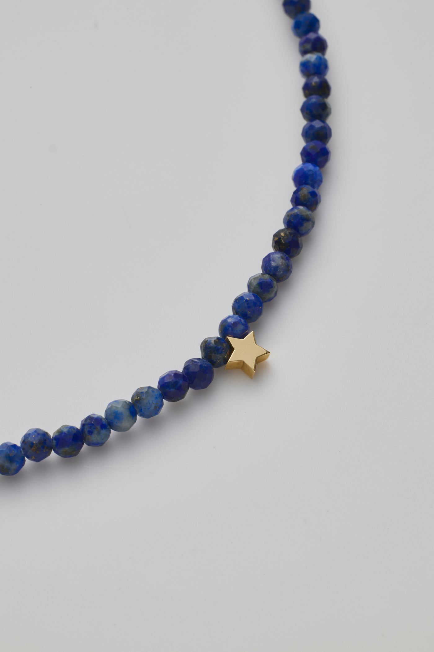 Delicate bracelet with Lapis lazuli beads and a gold star charm, elegantly crafted.