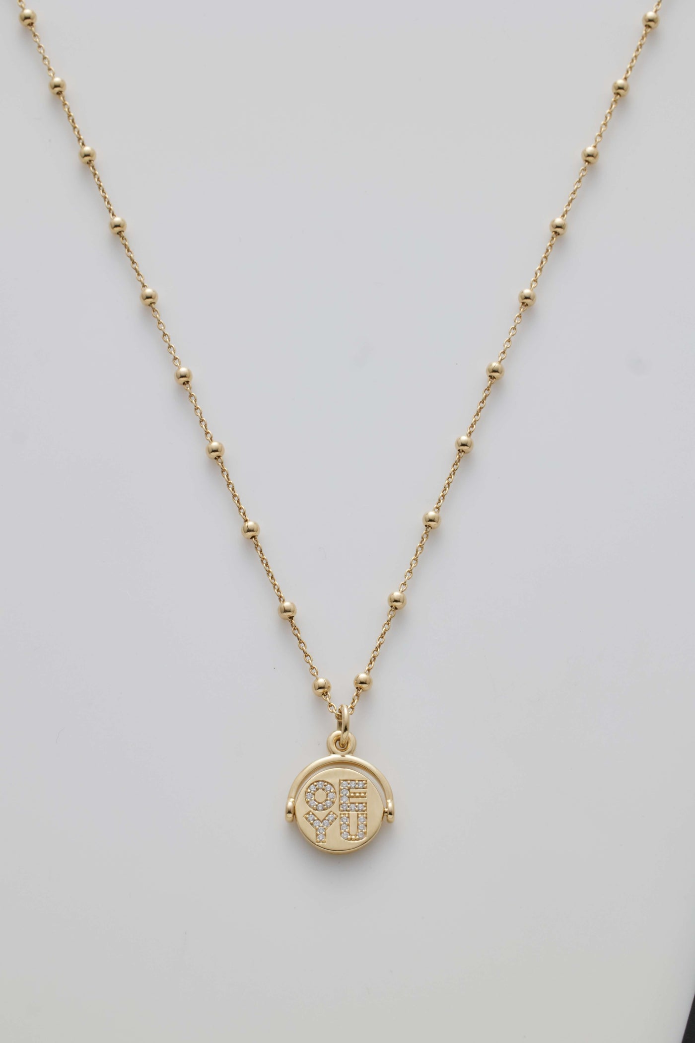 Gold necklace with spheres and a diamond-set spinner pendant revealing "I Love You" when spun.