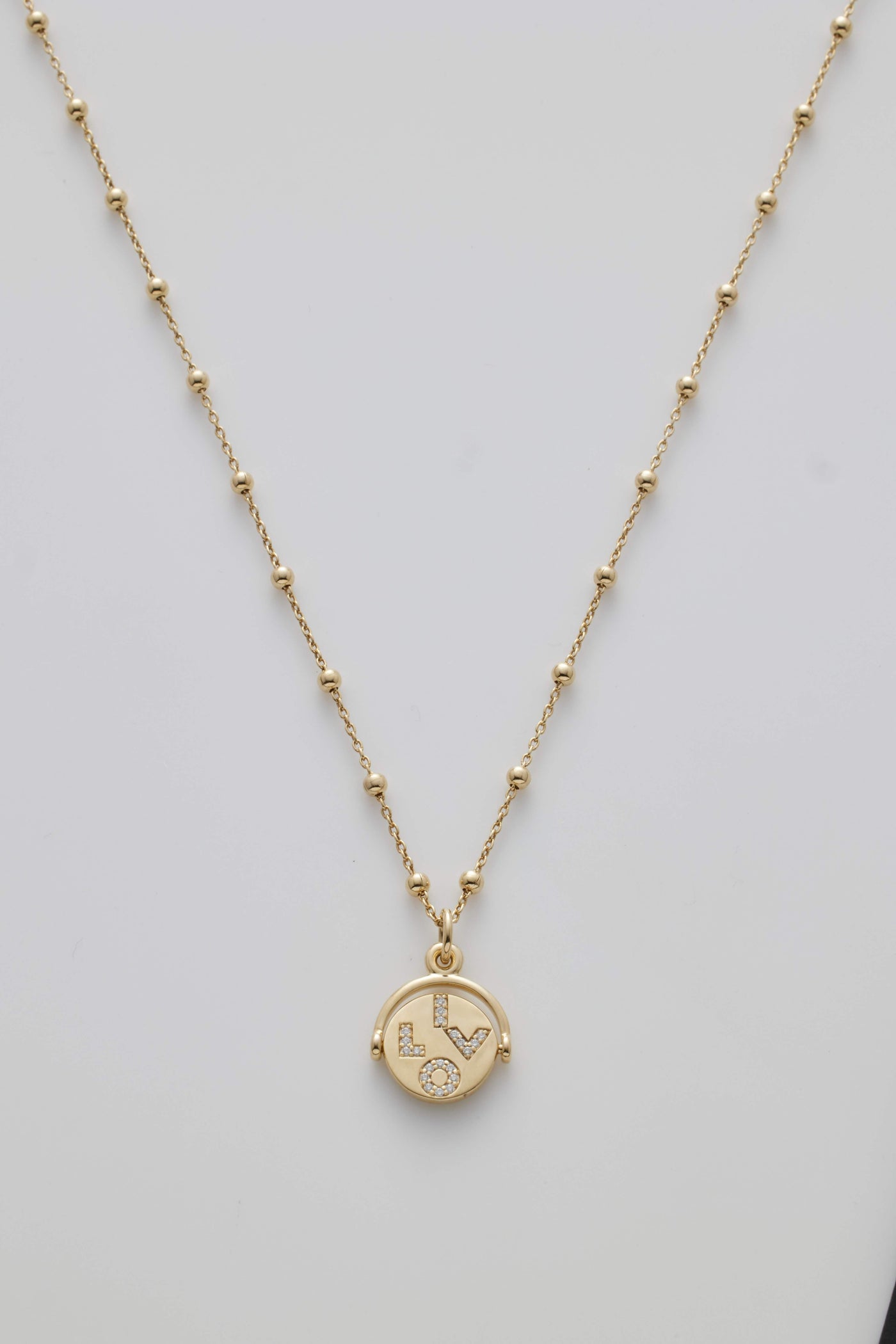 Gold necklace with spheres and a diamond-set spinner pendant revealing "I Love You" when spun.