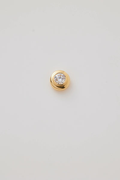 Close-up photograph of an April Birthstone Charm set featuring a genuine diamond in a gold bubble setting. The charm sparkles with elegance, showcasing its intricate craftsmanship against a soft, neutral background.