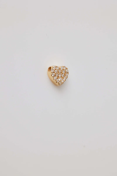 A close-up side view of a diamond-accented solid gold heart pendant. The heart's edges are smooth and polished, with a small opening at the top designed for a chain to thread through the pendant hole. The pendant's side profile highlights its depth and thickness, with the diamonds subtly encrusted along the heart's curve, adding sparkle and elegance.