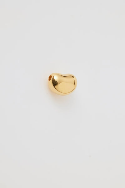 Side profile of a small gold bean-shaped charm with a smooth, polished finish and hole through the centre for threading a necklace chain. 