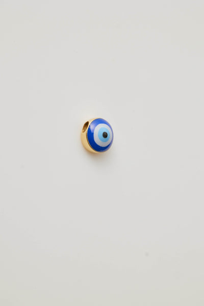 Side view with hole through a gold and enamel Turkish eye charm featuring a vibrant blue and white eye design. 