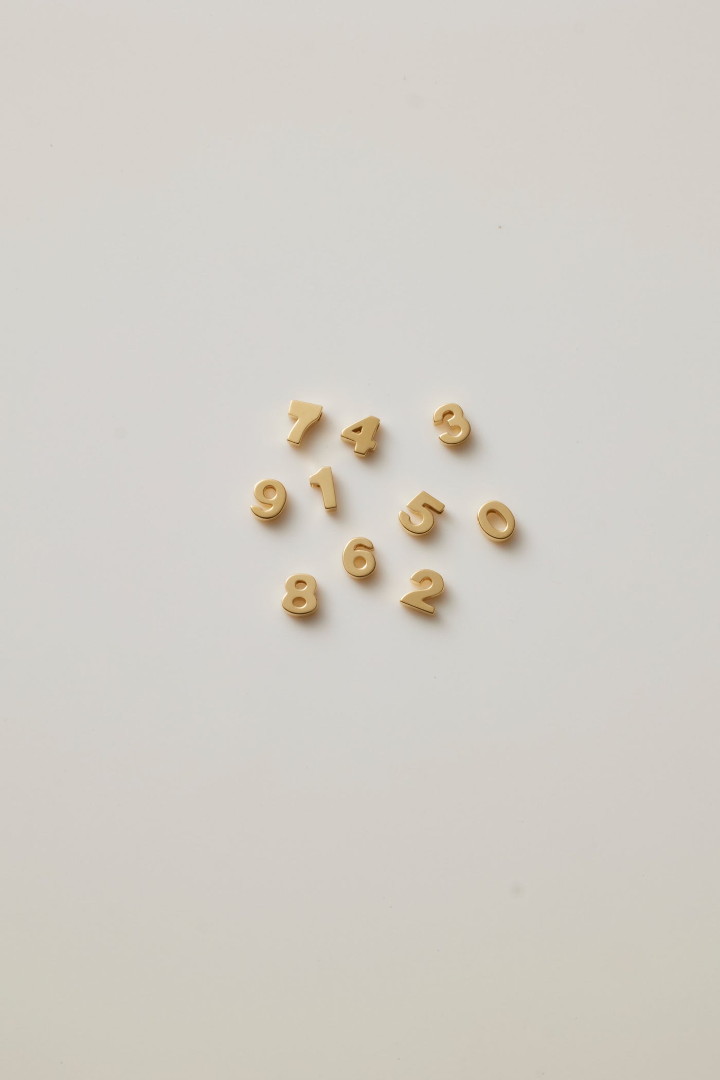 A photo showing gold numbers from 0-9 which symbolises luck and individuality, offering a timeless and elegant way to celebrate a milestone or important date.