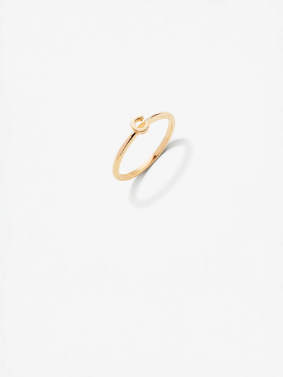 The Letter C Ring in 18k gold is a minimalist piece featuring a small, elegant loop on top. Set against a white background, the ring's faint shadow accentuates its sleek and delicate design. Custom sizes are available to ensure the perfect fit for this exquisite piece.