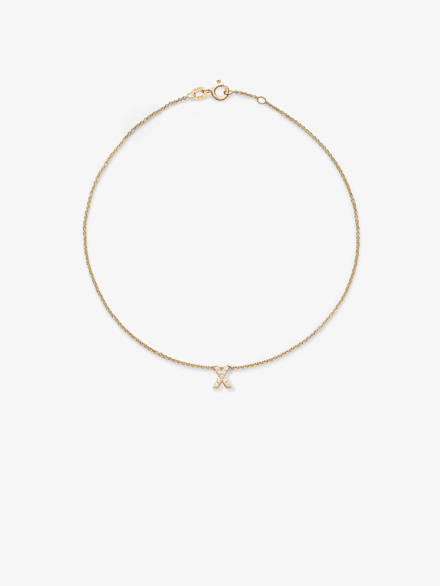 The Letter X Bracelet in Diamonds and 18k Gold features a delicate 18k solid gold chain adorned with a tiny letter "X" pendant encrusted with diamonds. The chain has a small clasp at the top for fastening and is presented against a plain white background.