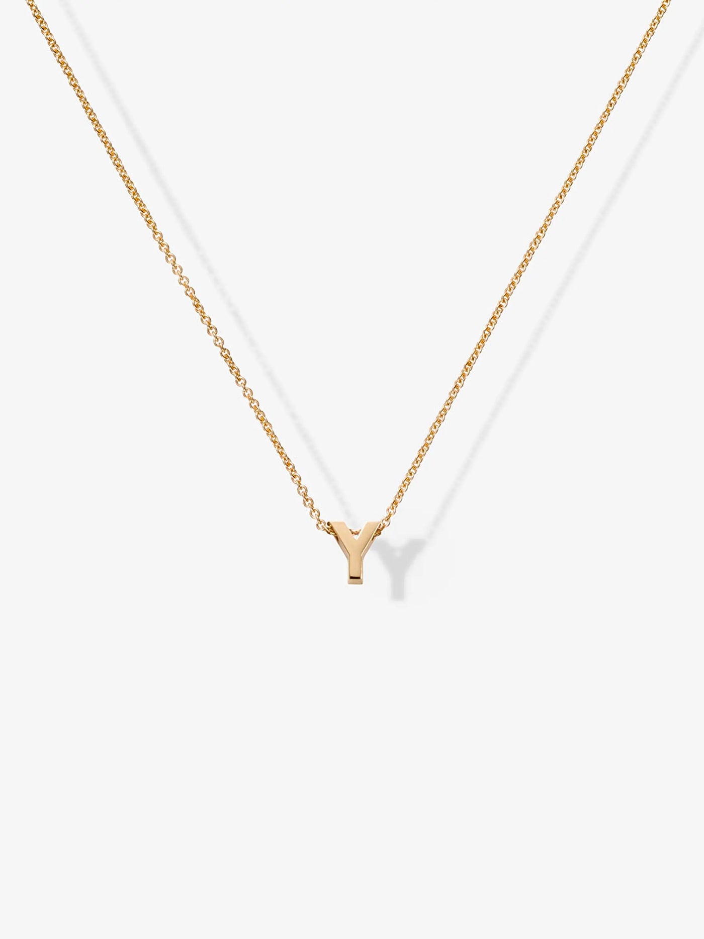 A delicate Letter Y Necklace in 18k Gold, featuring a small gold letter "Y" pendant gracefully hanging from a fine 18k solid gold chain. The necklace is elegantly displayed against a plain white background.