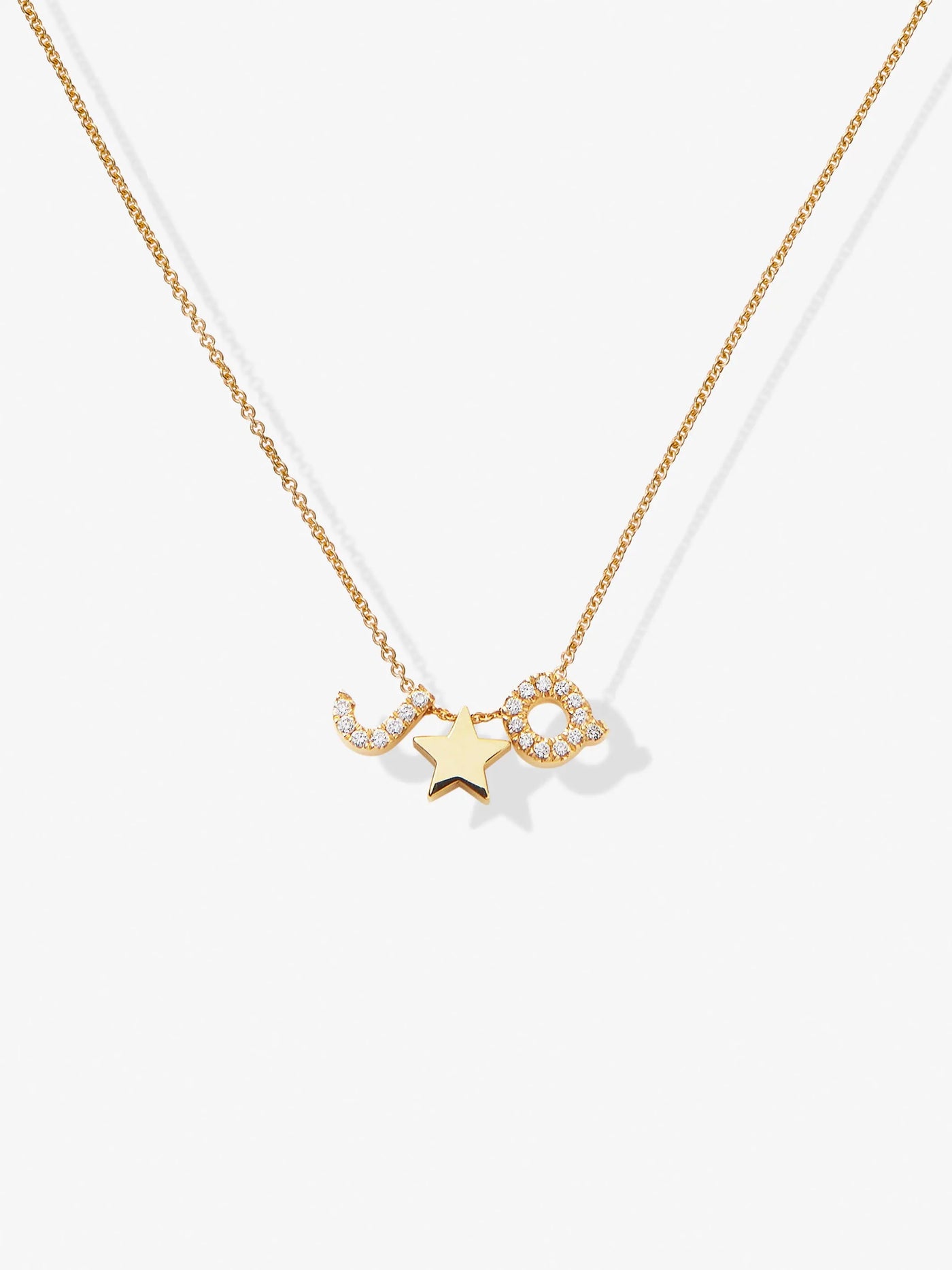 A delicate Two Letters and Star Necklace in Diamonds and 18k Gold with a chain featuring three diamond pendants: letters "JQ" encrusted with small diamonds, and a solid gold five-pointed star. The necklace is displayed on a white background.