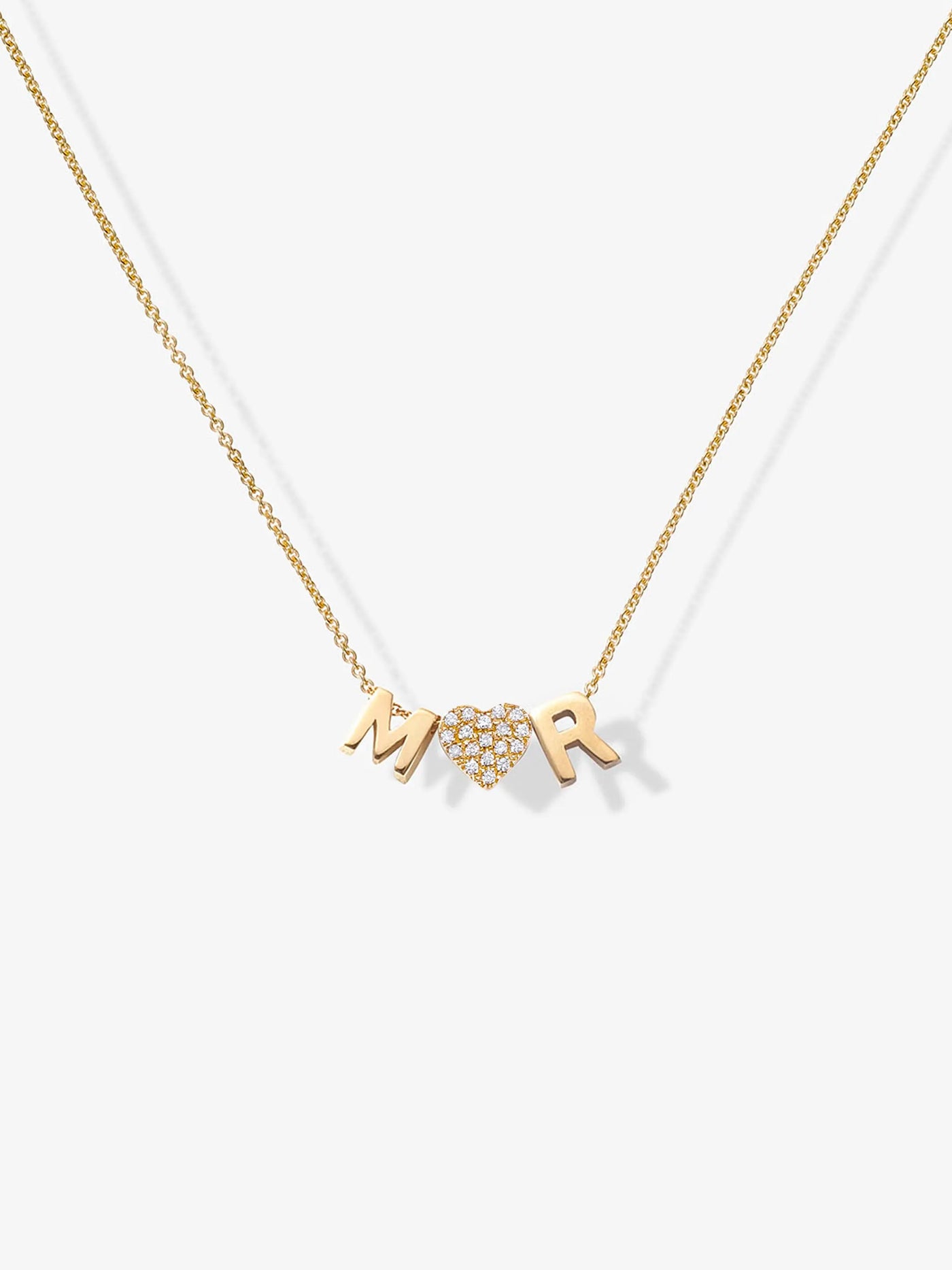 Introducing the Two Letters and Diamond Heart Necklace in 18k Gold: a delicate, solid gold piece that beautifully features the letters "M" and "R" alongside a heart-shaped charm embellished with small, sparkling diamonds nestled between them. Its thin and elegant chain flawlessly complements the minimalist design.