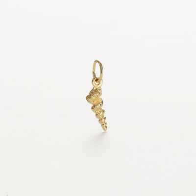 The Cone Shell Charm in 9k Gold is a small, intricately detailed pendant shaped like a seashell, measuring 15 mm x 5 mm. It features a loop at the top for easy attachment to a necklace or bracelet, set against a plain, light-colored surface.