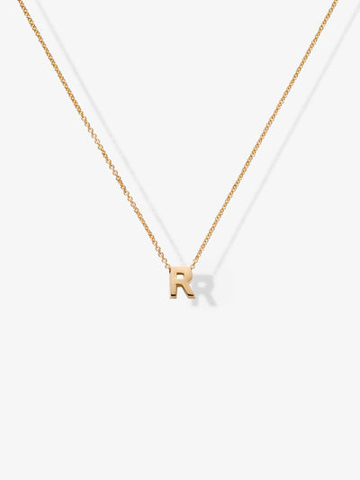 The Letter R Necklace in 18k Gold showcases a delicate fine chain and features a minimalist solid gold pendant in the shape of the letter "R," centered against a white background.