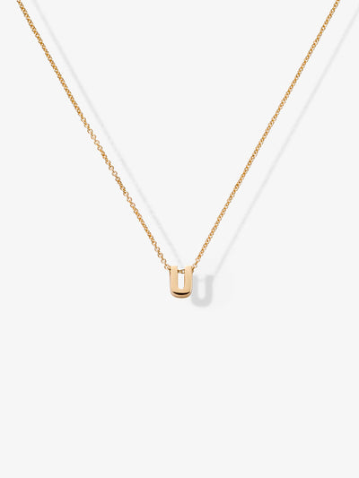 The Letter U Necklace in 18k Gold features a delicate rectangular pendant hanging at the center. Its fine chain showcases understated elegance and highlights the simplicity of its design. Set against a plain white background, this necklace seamlessly blends sophistication and charm.