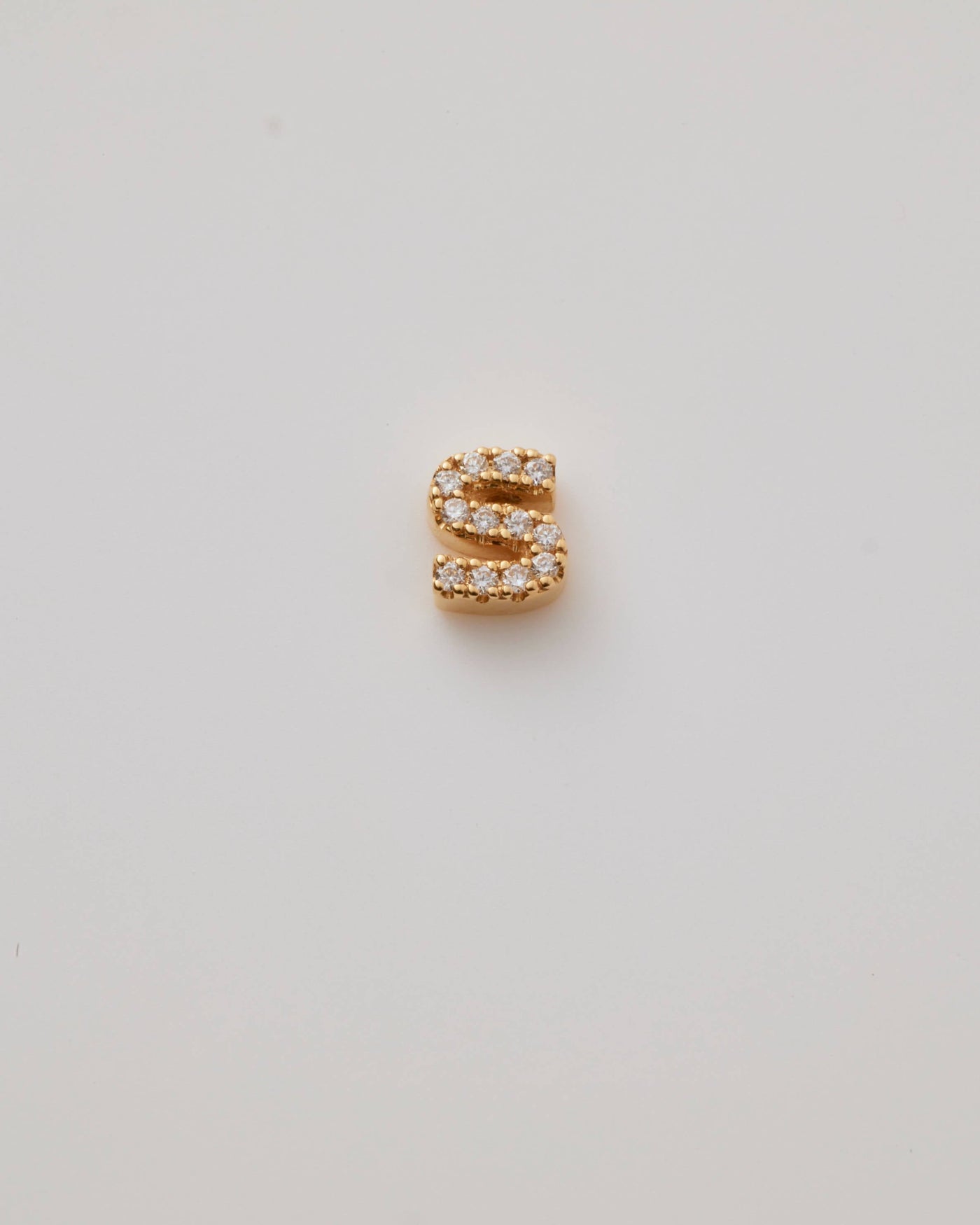 Small solid gold three-dimensional letter 'S' charm with pavé set diamonds, designed to thread onto a necklace chain.