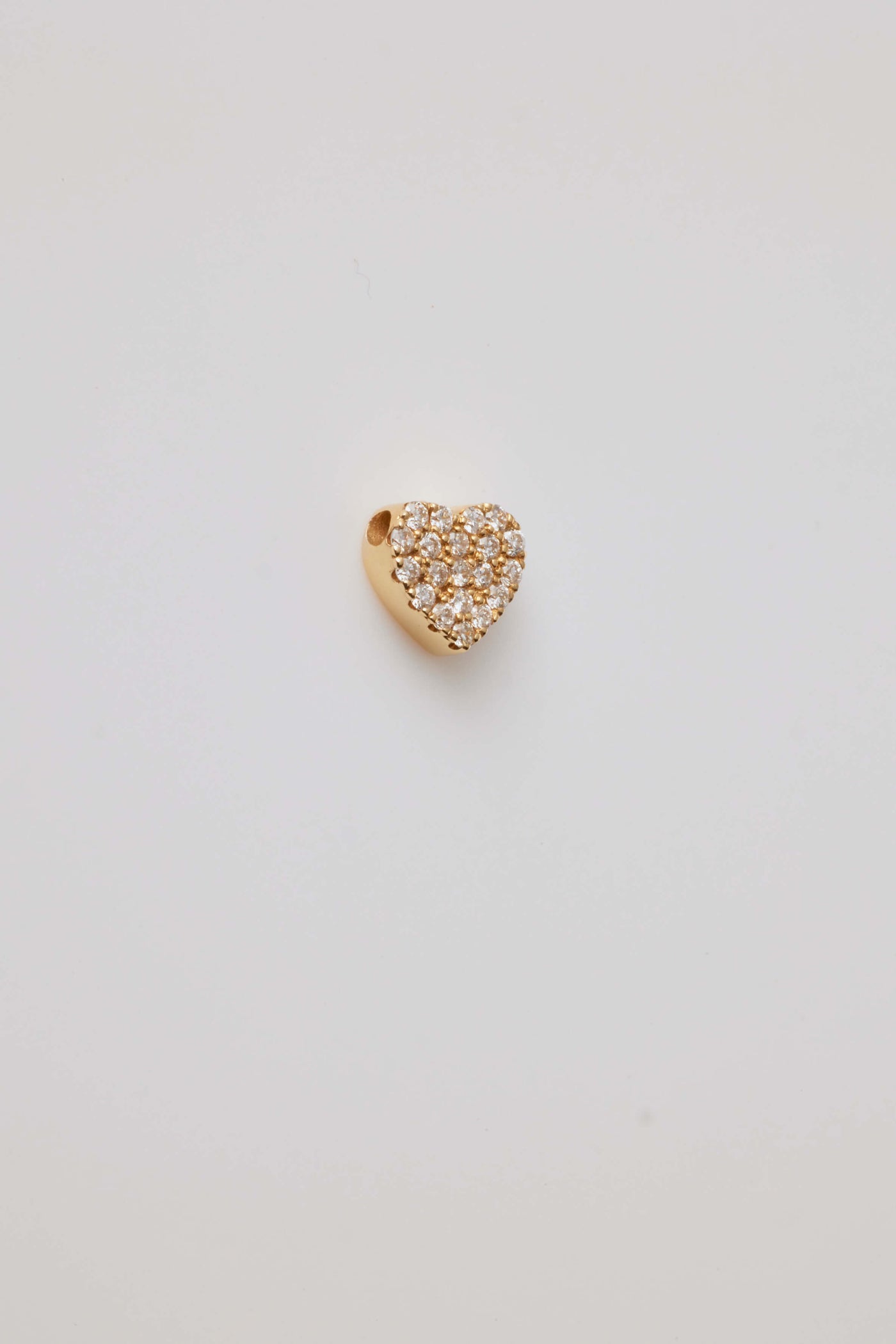 Solid gold heart charm with pavé-set diamonds, symbolizing love and elegance.
