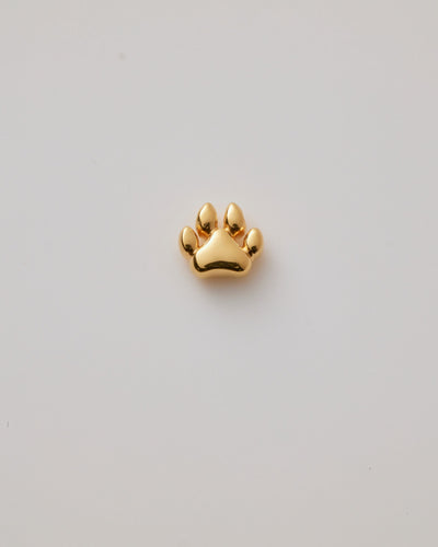 Small solid gold dog paw charm, designed to slide onto a necklace chain for a personalised jewellery piece.