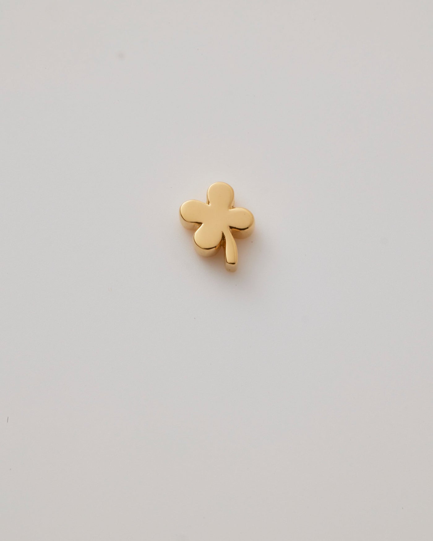Solid gold four-leaf clover charm representing luck, hope, faith, and love, designed to slide onto a necklace chain for a timeless keepsake