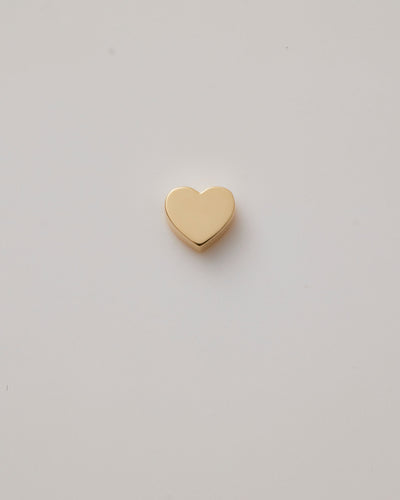 Small solid gold heart charm with a polished finish, designed to slide onto a necklace chain for customisable jewellery.