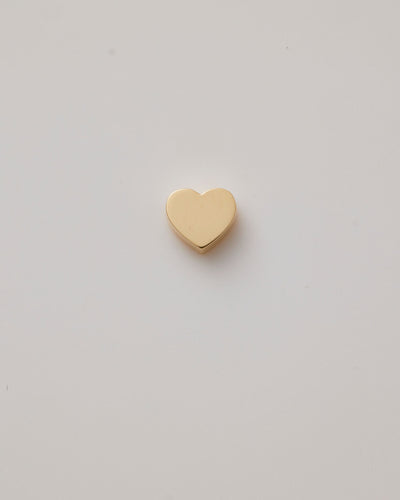 Small solid gold heart charm with a polished finish, designed to slide onto a necklace chain for customisable jewellery.