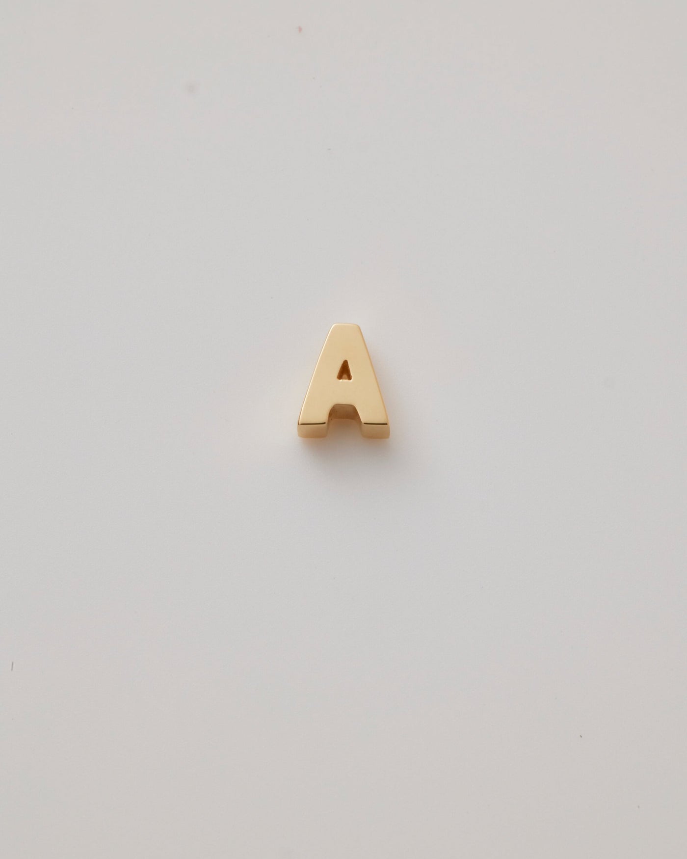 Small gold polished three-dimensional letter 'A' charm with a smooth finish, designed to thread onto a necklace chain.