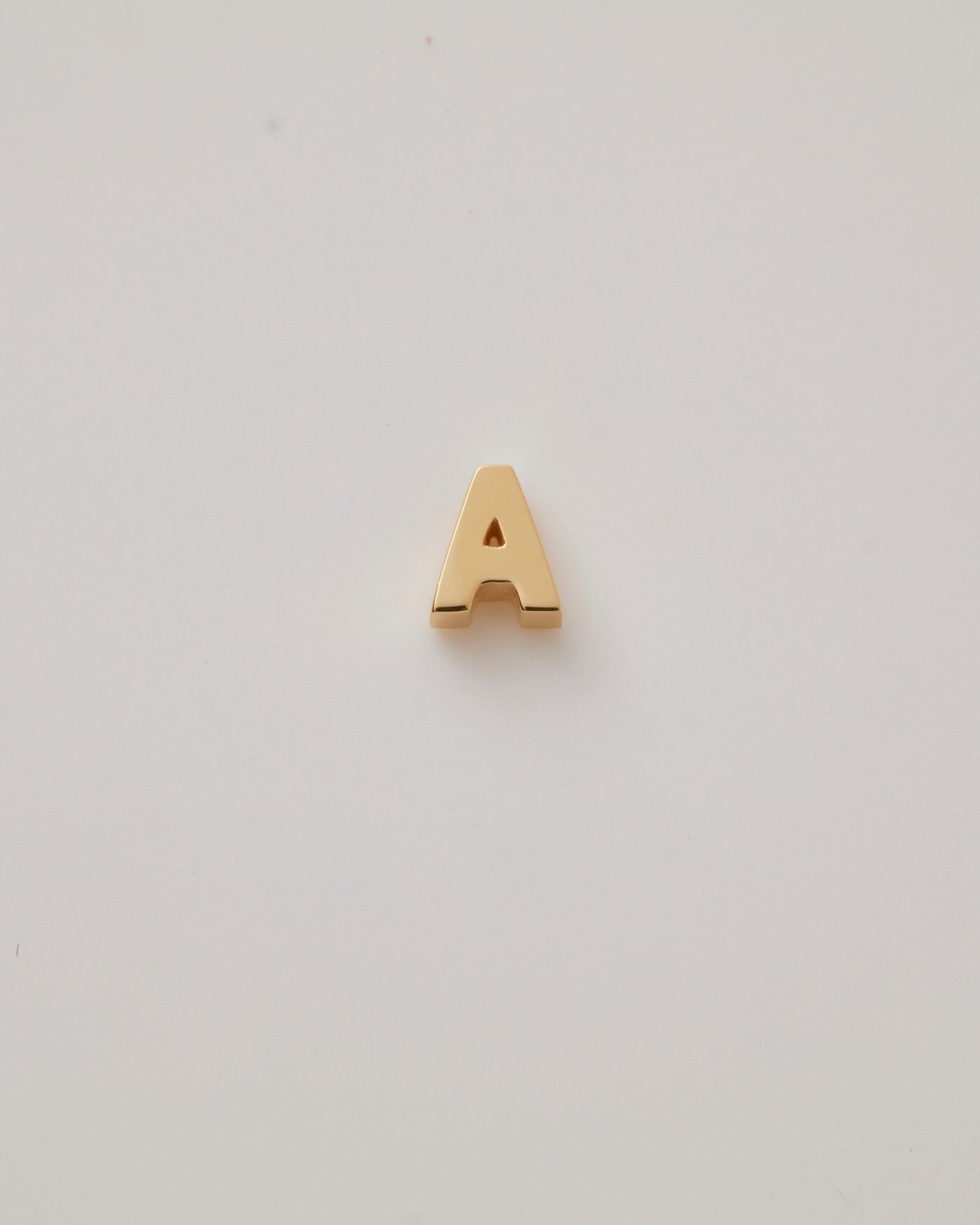 Small gold polished three-dimensional letter 'A' charm with a smooth finish, designed to thread onto a necklace chain.