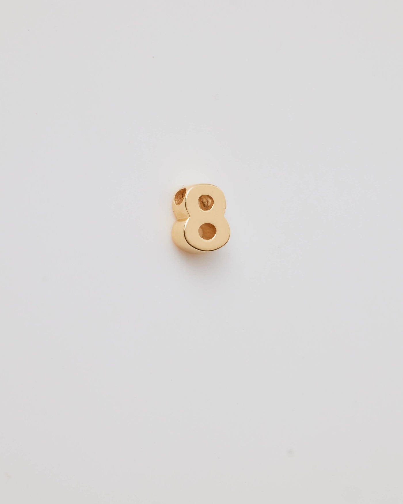 Small solid gold number charms (0-9), designed to slide onto a necklace chain for a personalised jewellery piece with symbolic meaning.