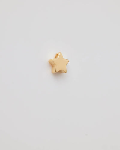 Polished solid gold star charm, a symbol of remembrance and love.