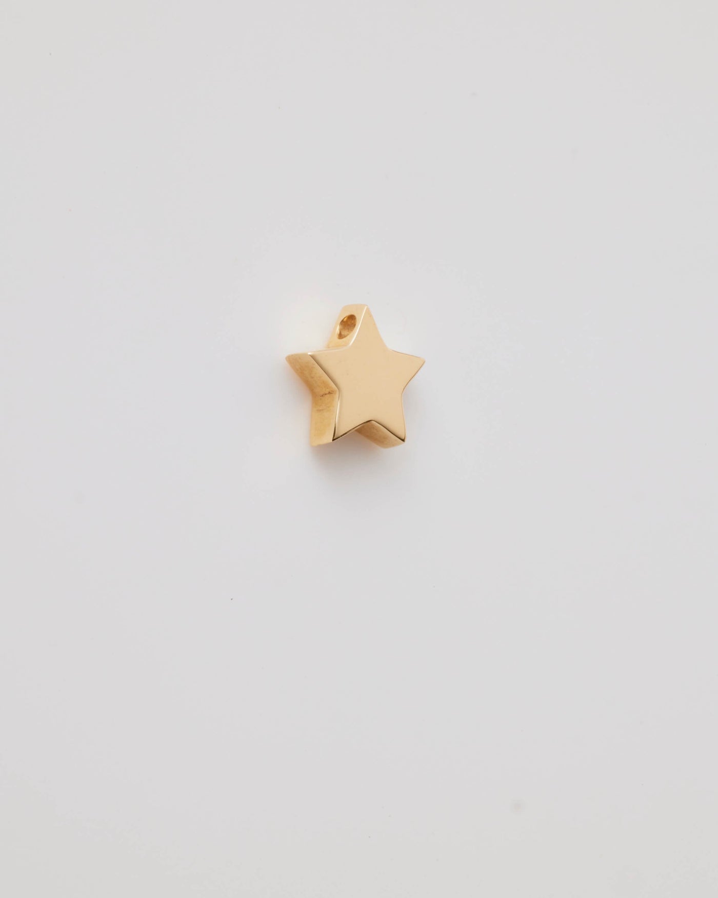 Polished solid gold star charm, a symbol of remembrance and love.