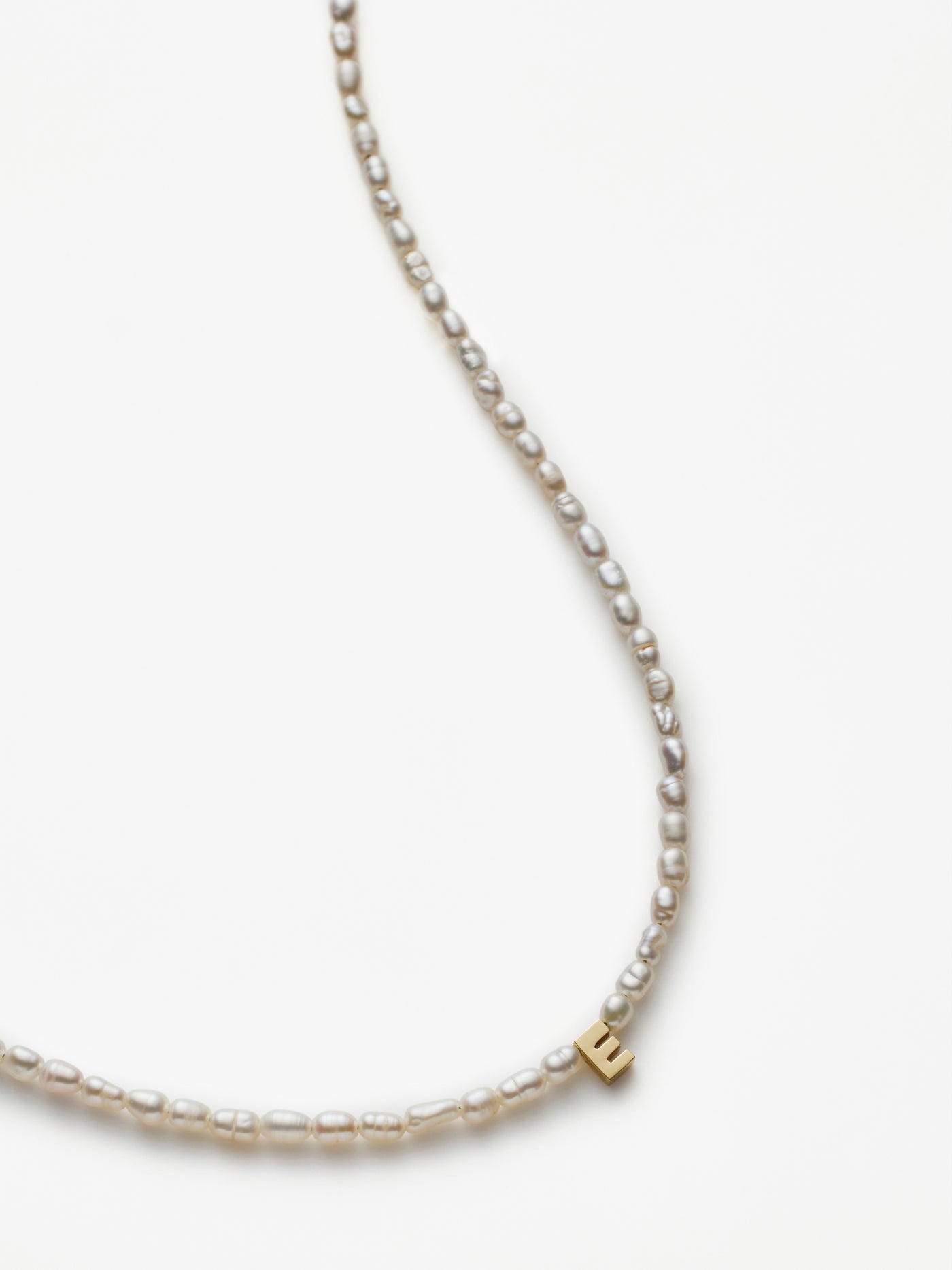 Hand-strung necklace with freshwater pearls and miniature three-dimensional letter 18k solid gold